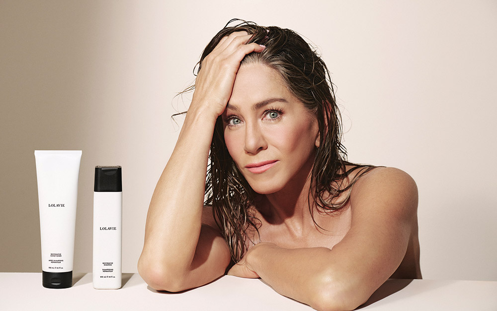Jennifer Aniston with products from her thriving hair care line, LolaVie.